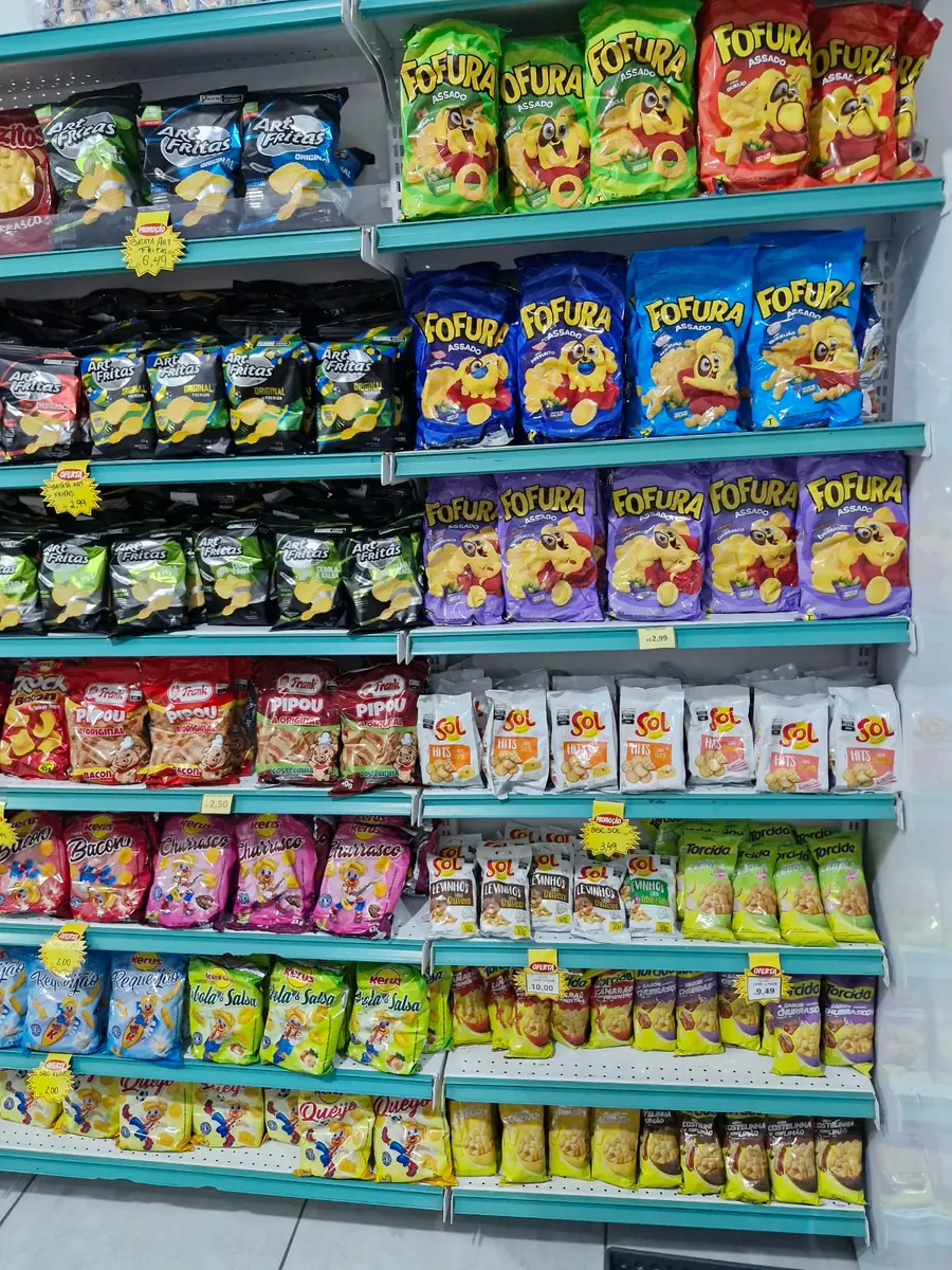 Prateleiras com salgadinhos de diversos tipos e pipocas.