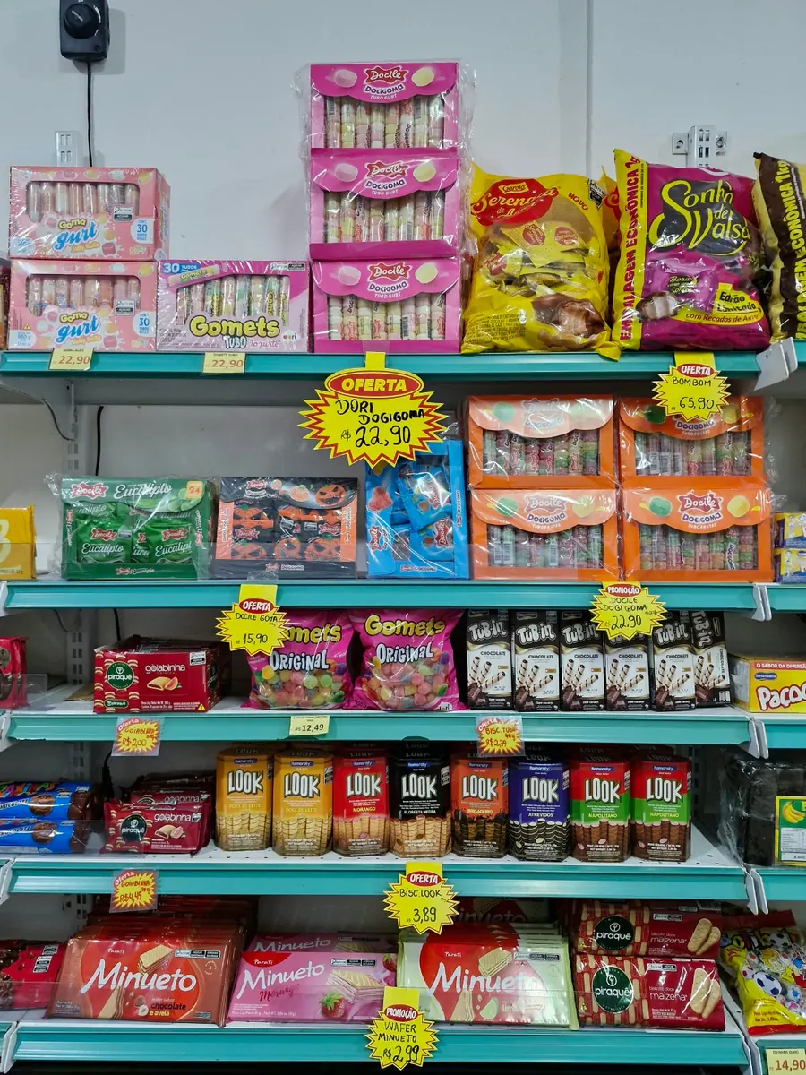 Prateleira com balas de goma, bombons, biscoitos e wafers.